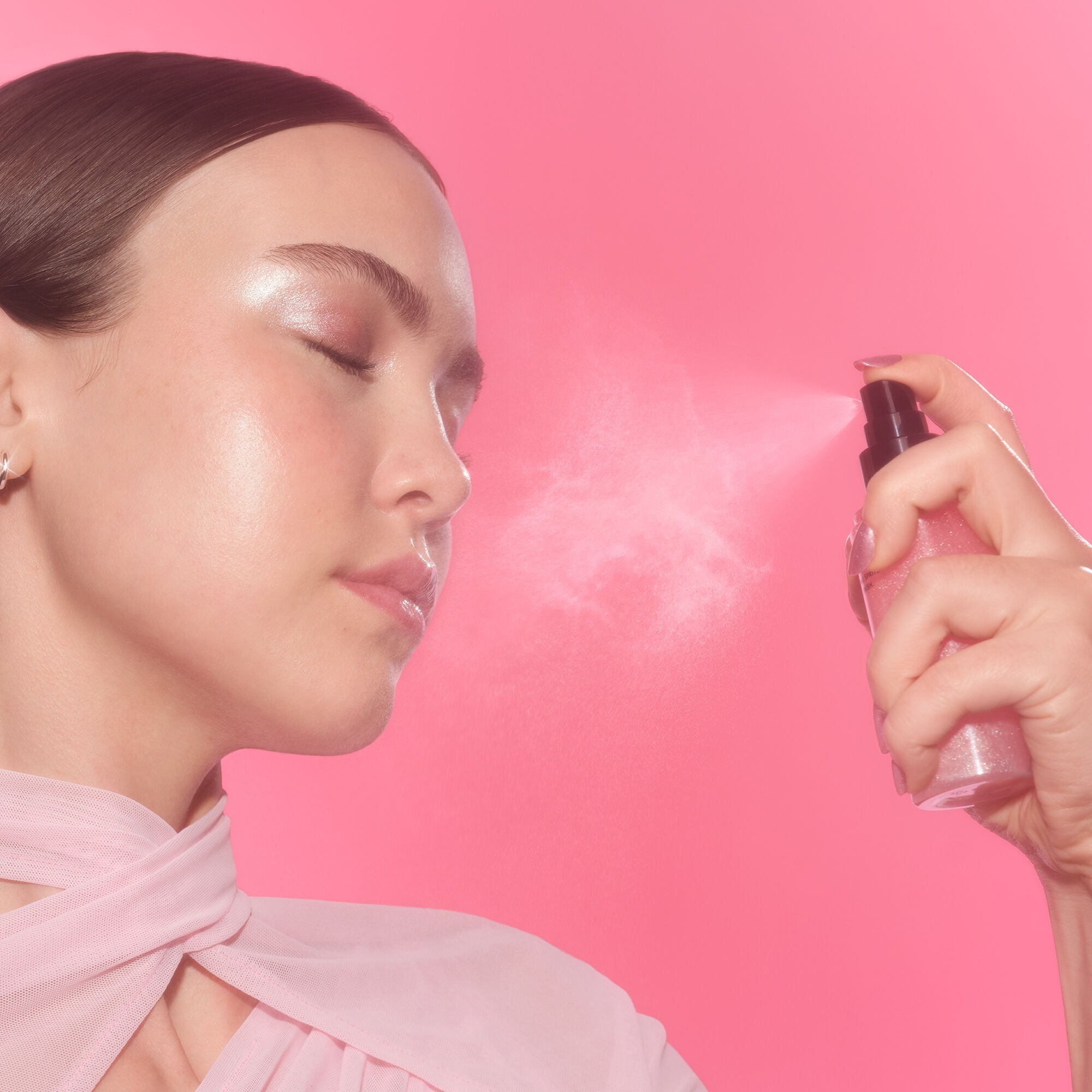 Woman Spraying Power Grip Rosé Setting Spray to Set Makeup