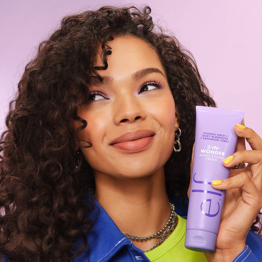 Woman with Curly Hair holding tube of e.l.f. 3-in-Wonder Magic Styling Cream